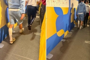 赖斯赛后步履蹒跚穿越混合采访区，左小腿绑着绷带